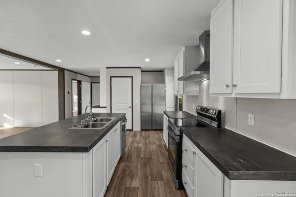 a kitchen with stainless steel appliances granite countertop a sink stove and refrigerator