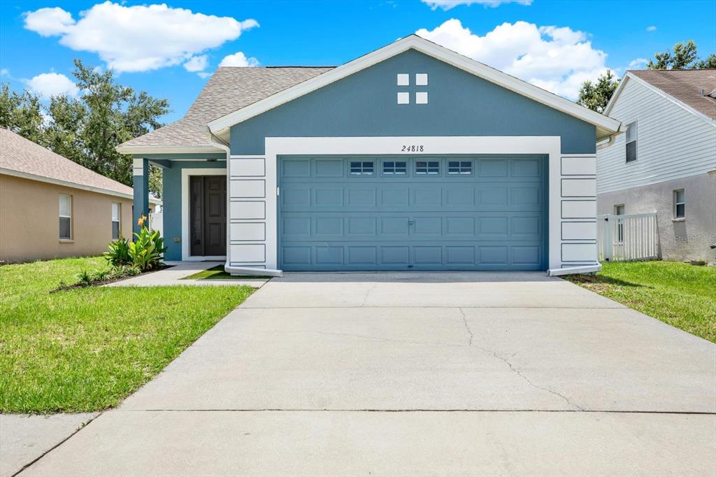 24818 Siena Drive Lutz, FL 33559 - Photo 1 of 1 a front view of a house with a yard and garage