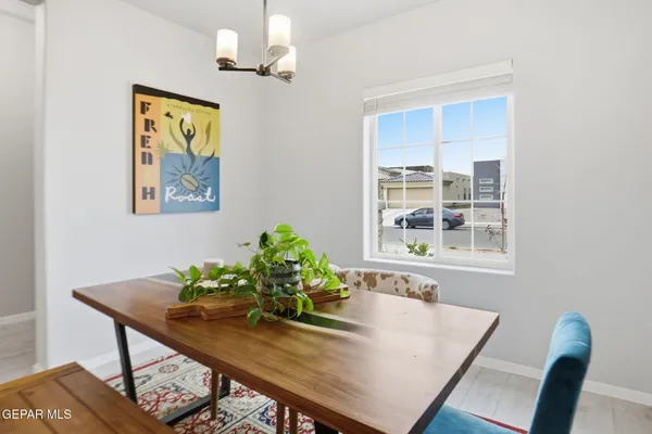 a kitchen with stainless steel appliances a table chairs refrigerator and microwave