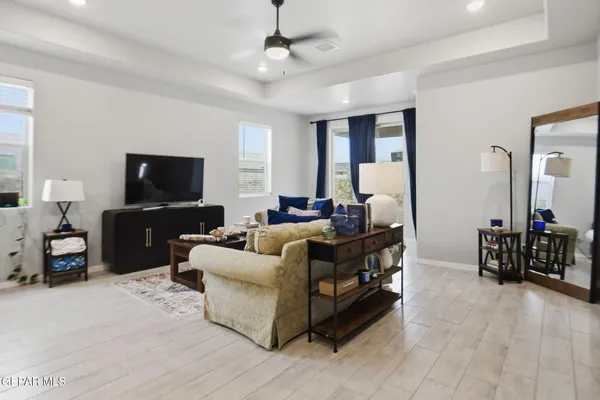a living room with furniture kitchen view and a chandelier