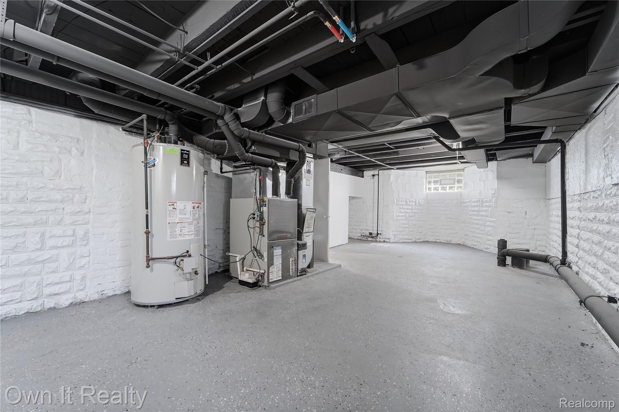 168 Kerby Road Grosse Pointe, MI 48236 - Photo 32 of 36 Interior space featuring a water heater, furnace, painted block walls, exposed overhead ductwork, and a concrete floor