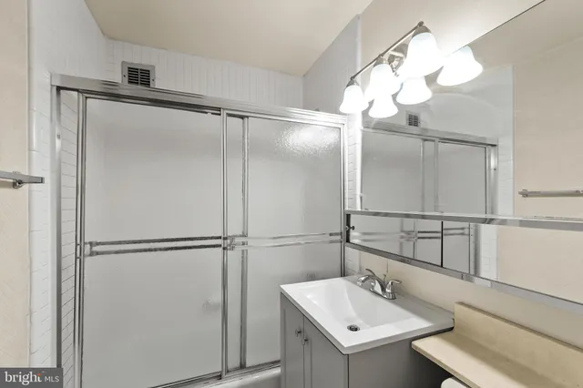 a bathroom with a mirror and a glass shower door