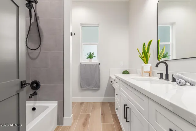 a bathroom with a granite countertop sink a mirror and shower