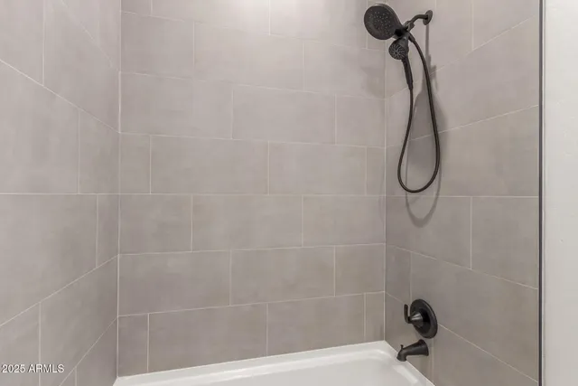 a bathroom with a bath tub with a shower