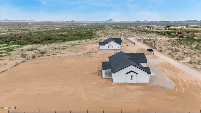an aerial view of a house with a yard and ocean view