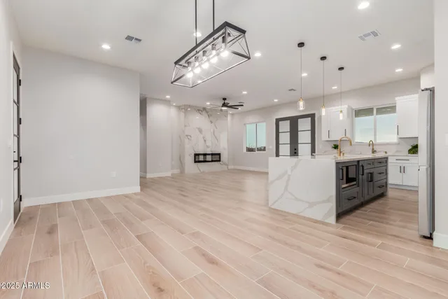 a view of a kitchen with kitchen island stainless steel appliances refrigerator stove microwave and cabinets