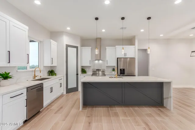 a large kitchen with a lot of counter space and wooden floor