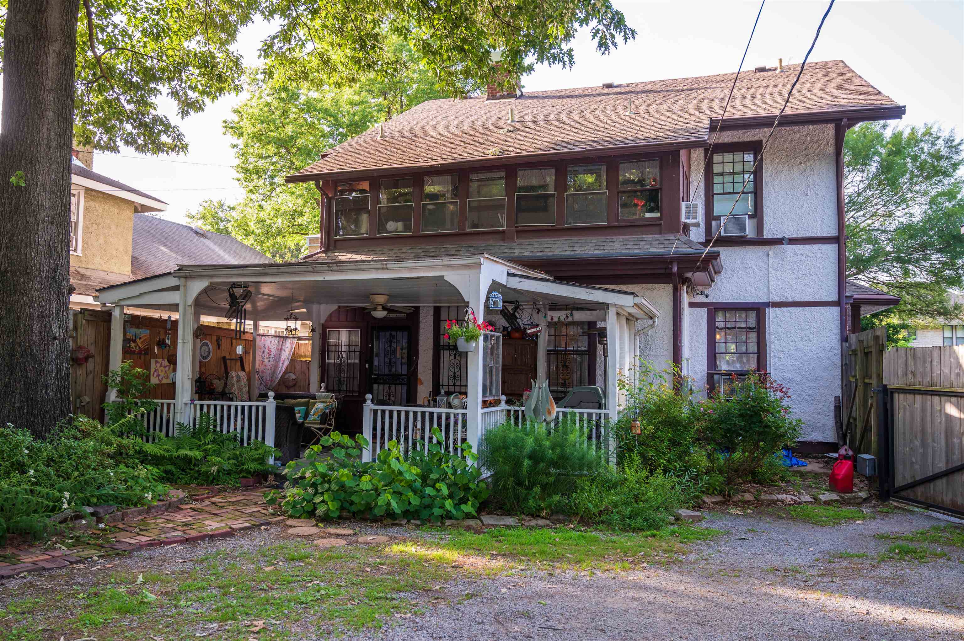 1267 Central Avenue Memphis, TN 38104 - Photo 18 of 25 a view of brick house with potted plants and a large tree
