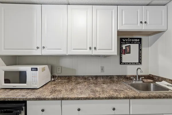 a kitchen with granite countertop white cabinets and a sink