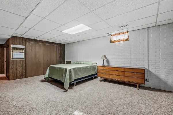 a spacious bedroom with a bed and a dresser