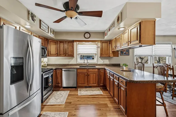 a kitchen with stainless steel appliances granite countertop a sink a stove and refrigerator