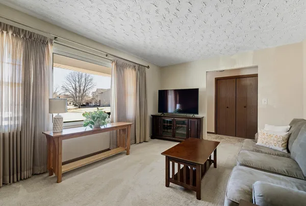 a living room with furniture a flat screen tv and a large window