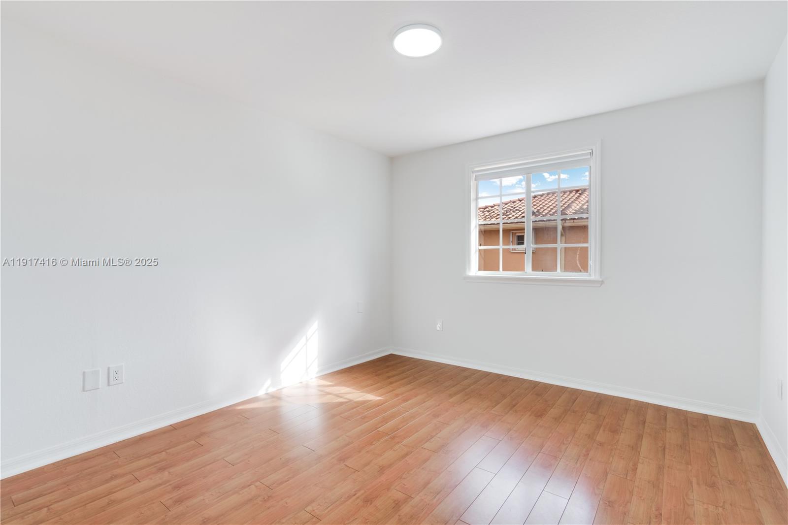 9481 Southwest 78th Avenue Miami, FL 33156 - Photo 22 of 45 an empty room with wooden floor and windows