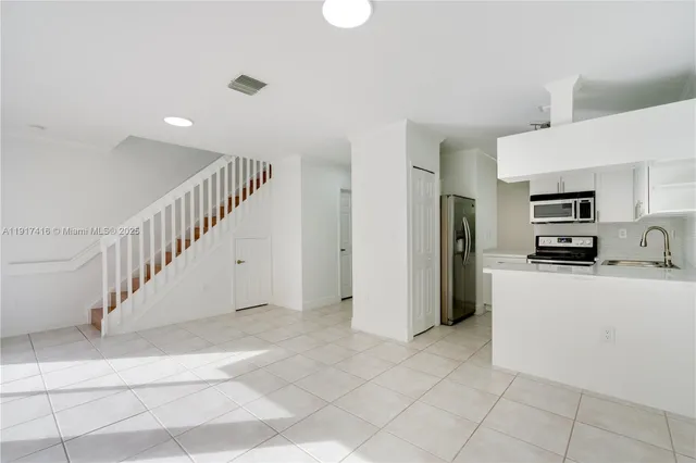 a kitchen with stainless steel appliances a stove microwave and a refrigerator