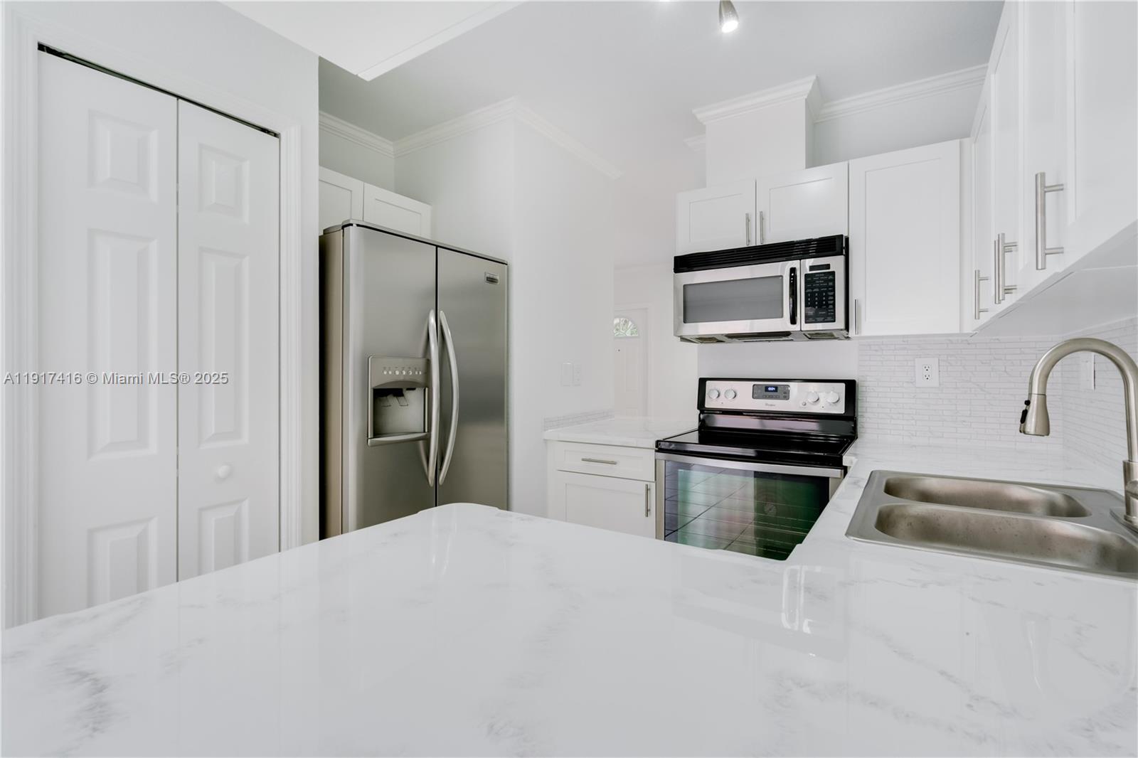 9481 Southwest 78th Avenue Miami, FL 33156 - Photo 10 of 45 a kitchen with stainless steel appliances kitchen island a refrigerator sink and stove