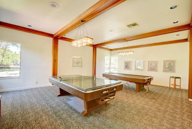 a kitchen with stainless steel appliances a dining table chairs and a refrigerator
