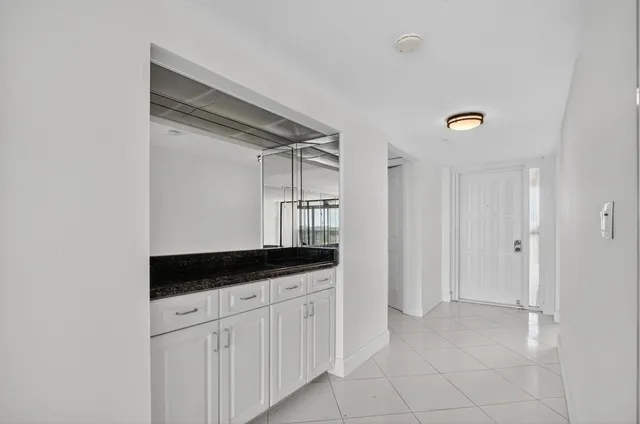 a kitchen with white cabinets and black appliances