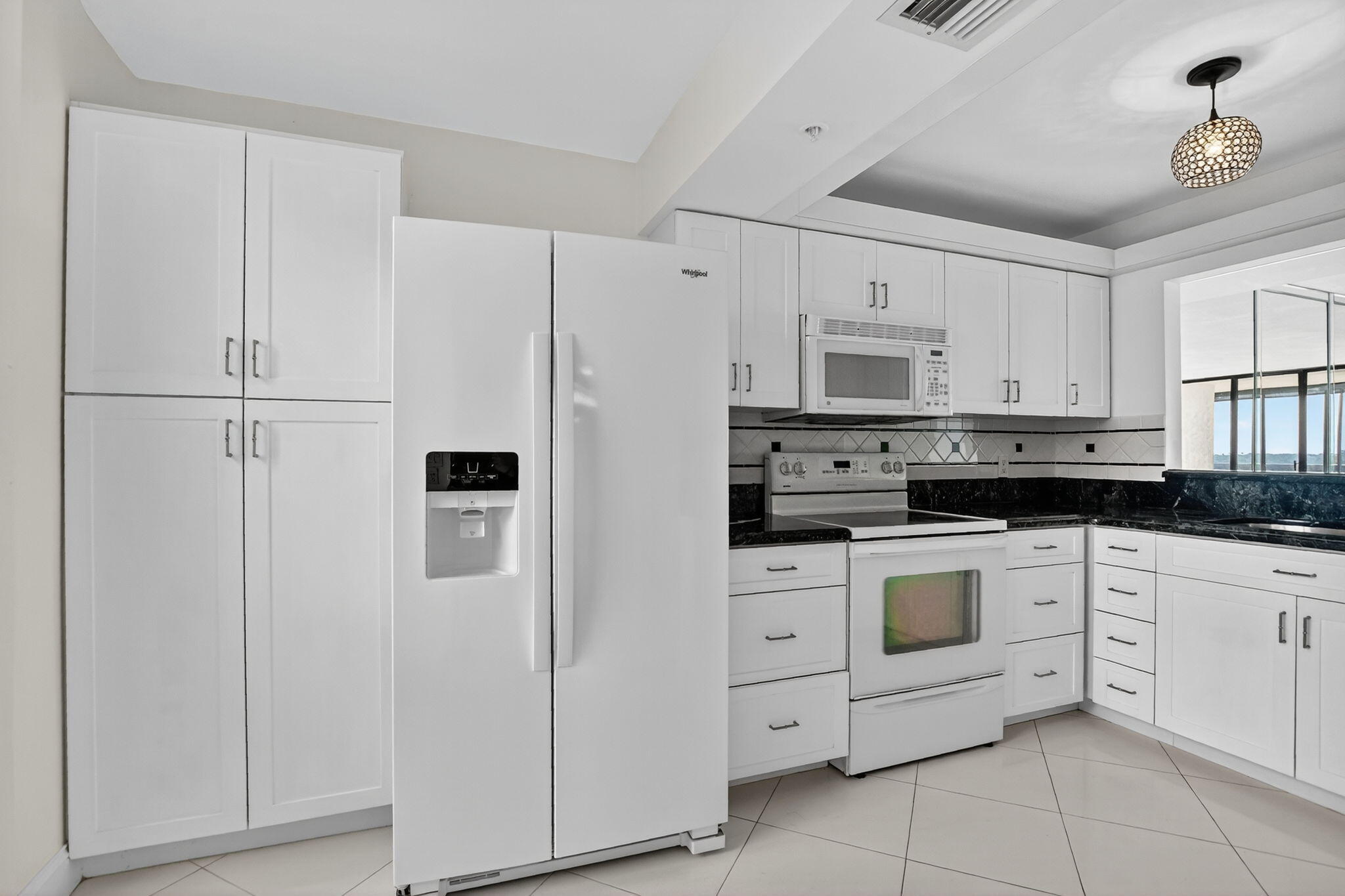 6620 Boca Del Mar Drive, Unit 706 Boca Raton, FL 33433 - Photo 8 of 41 a kitchen with white cabinets and white appliances