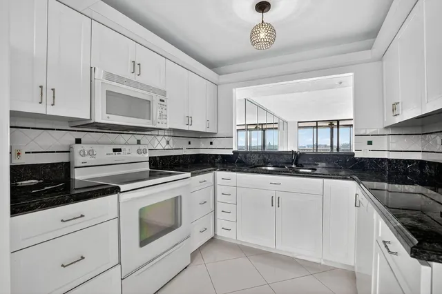 a kitchen with white cabinets stainless steel appliances and sink