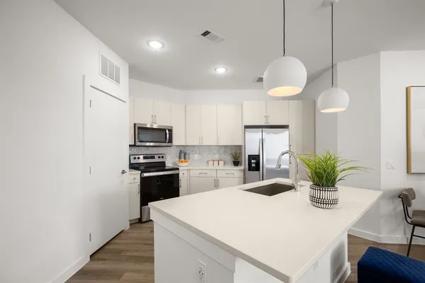 a kitchen with a refrigerator a stove and cabinets