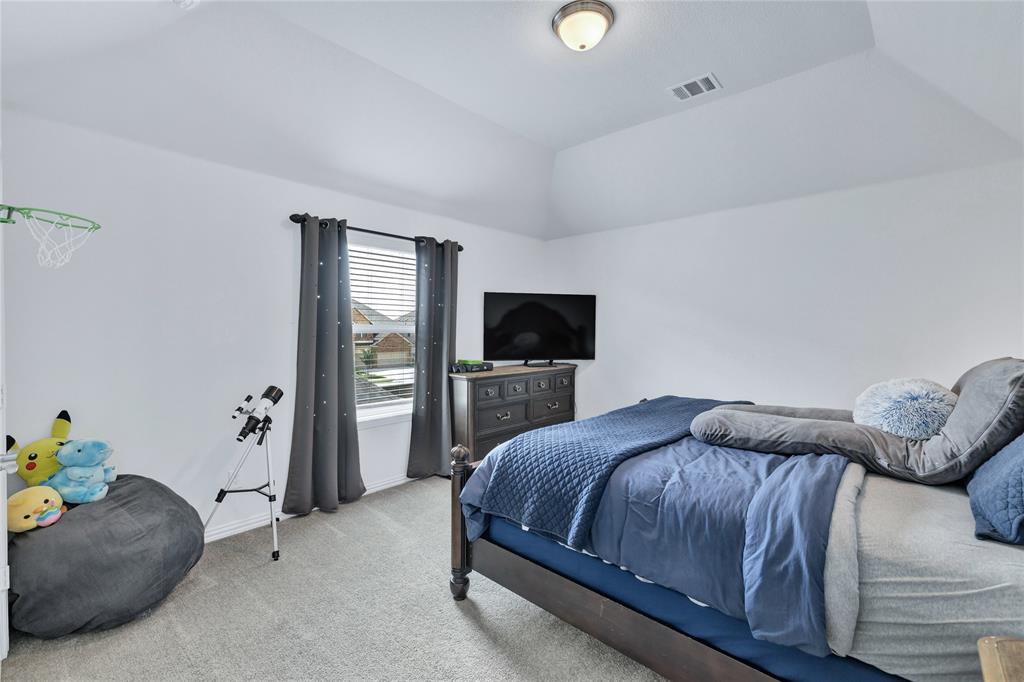 566 Long Meadow Drive Haslet, TX 76052 - Photo 25 of 36 a bedroom with a bed and flat screen tv