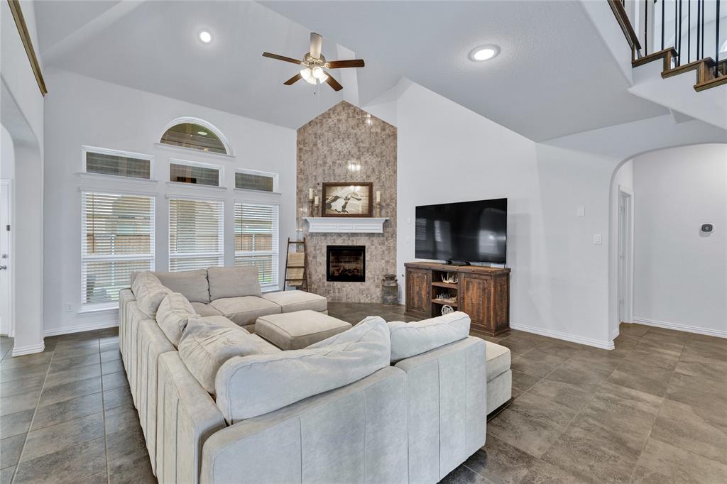566 Long Meadow Drive Haslet, TX 76052 - Photo 3 of 36 a living room with furniture a flat screen tv and a fireplace