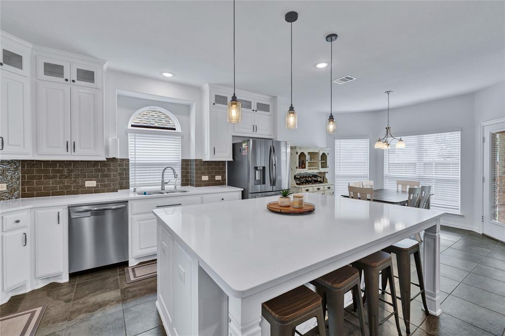 566 Long Meadow Drive Haslet, TX 76052 - Photo 7 of 36 a kitchen with sink a stove and chairs