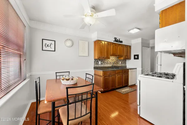 a kitchen with granite countertop a stove a sink and a refrigerator with wooden floor