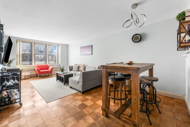 a living room with furniture a flat screen tv and a window