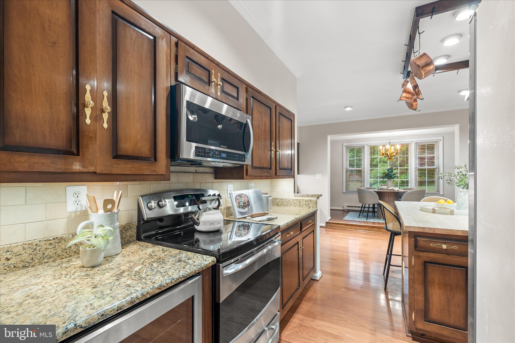 10205 Old Hunt Road Vienna, VA 22181 - Photo 27 of 67 a kitchen with granite countertop a sink a stove and cabinets