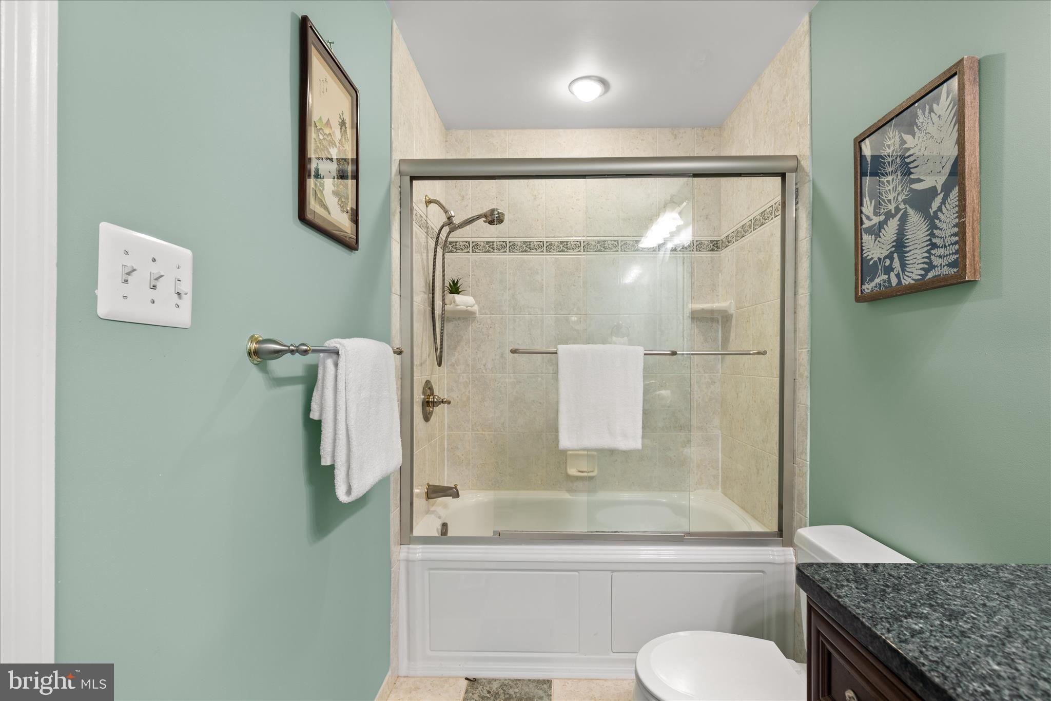 10205 Old Hunt Road Vienna, VA 22181 - Photo 44 of 67 a bathroom with a granite countertop toilet sink and shower