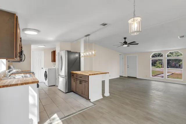 a kitchen with stainless steel appliances granite countertop a refrigerator and a sink