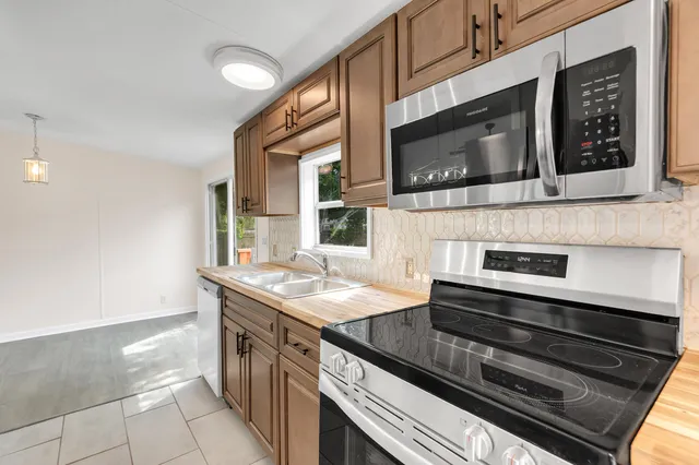a kitchen with stainless steel appliances kitchen island granite countertop a stove microwave and sink