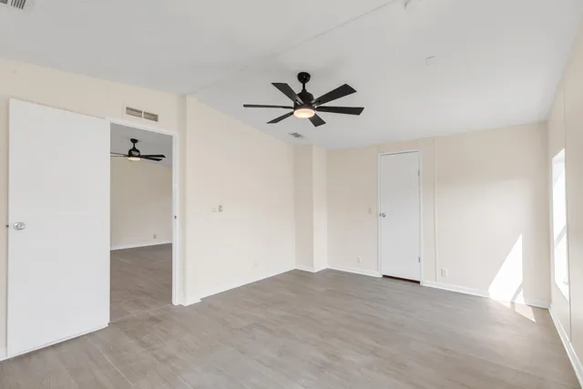 an empty room with closet and windows