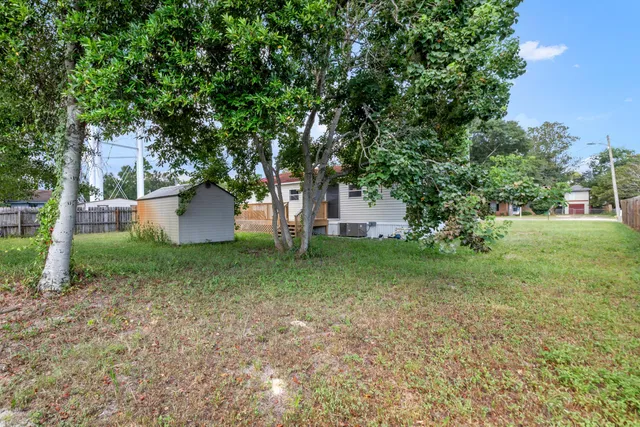 a view of a house with a small yard and wooden floor and fence