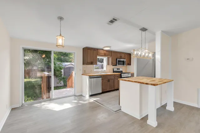 a kitchen with stainless steel appliances kitchen island granite countertop a sink and a stove