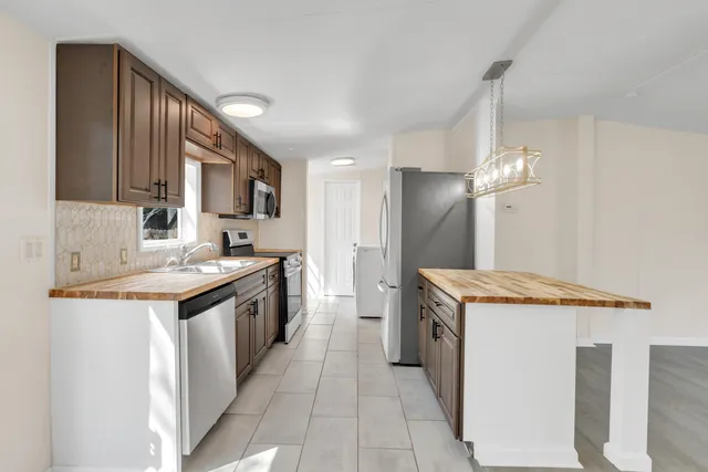 a kitchen with stainless steel appliances granite countertop a sink and a stove