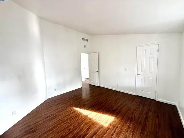 a view of an empty room with wooden floor