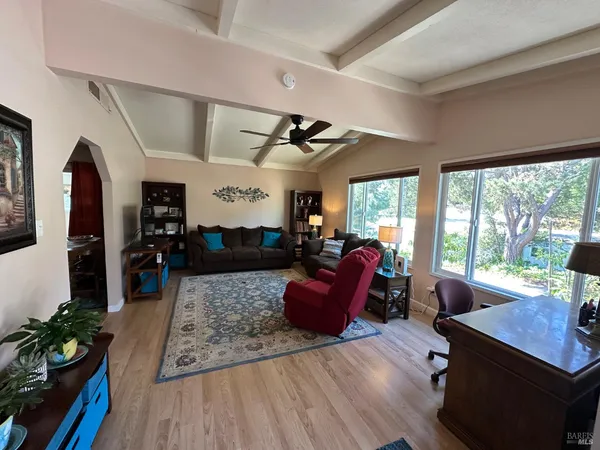 a living room with furniture a wooden floor and a large window