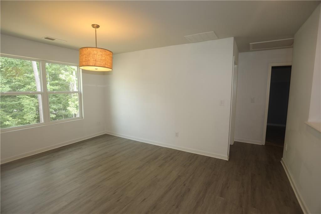 25 Lena Court Covington, GA 30016 - Photo 12 of 36 an empty room with wooden floor and chandelier