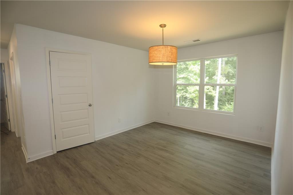 25 Lena Court Covington, GA 30016 - Photo 13 of 36 an empty room with wooden floor chandelier and window