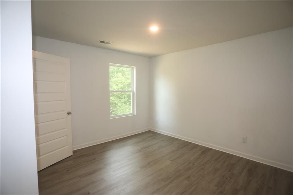 25 Lena Court Covington, GA 30016 - Photo 14 of 36 an empty room with wooden floor and windows