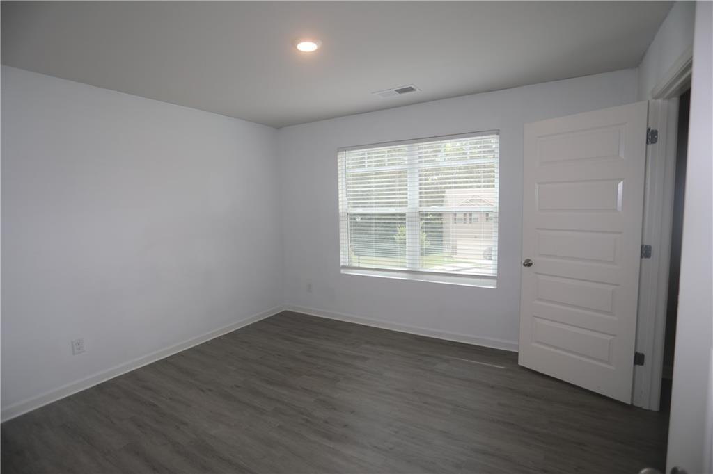 25 Lena Court Covington, GA 30016 - Photo 19 of 36 an empty room with wooden floor and windows