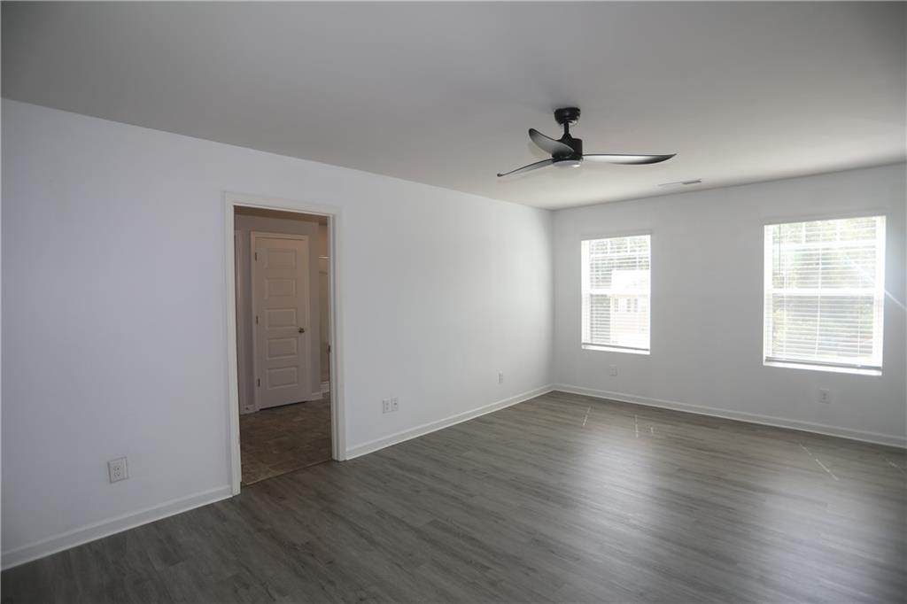 25 Lena Court Covington, GA 30016 - Photo 24 of 36 an empty room with wooden floor ceiling fan and windows