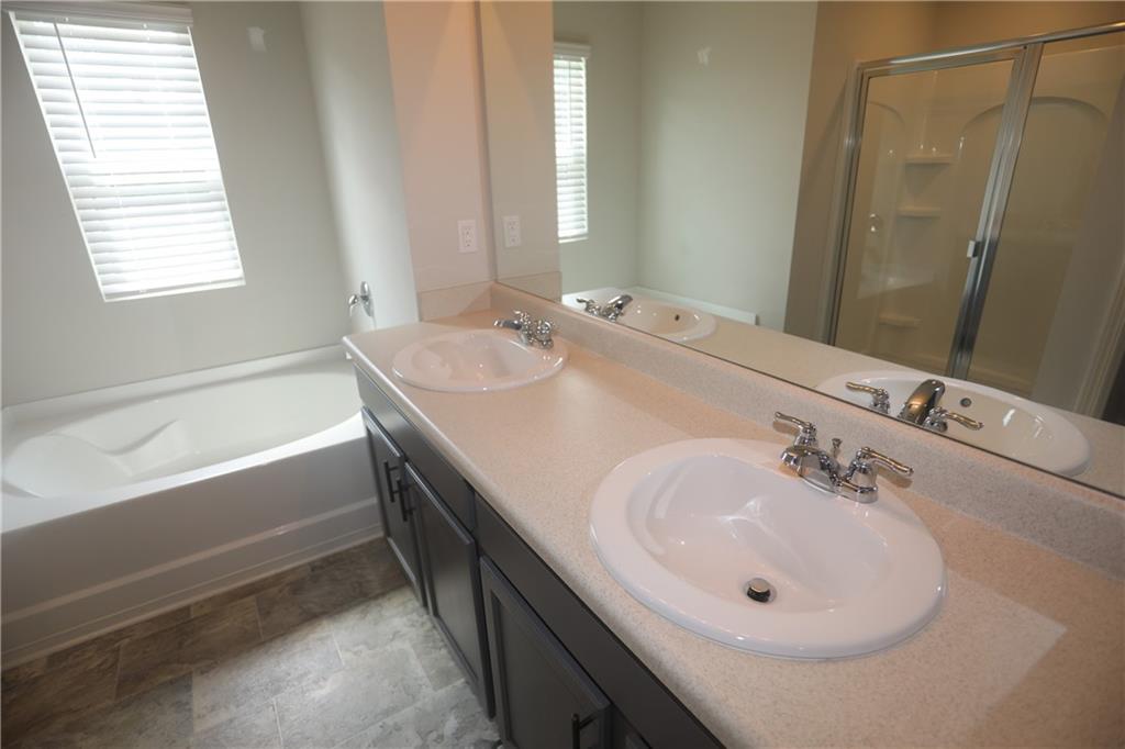 25 Lena Court Covington, GA 30016 - Photo 30 of 36 a bathroom with a double vanity sink and a bathtub