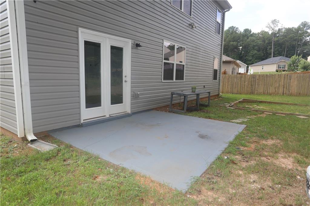 25 Lena Court Covington, GA 30016 - Photo 34 of 36 a view of a backyard with table and chairs and wooden fence