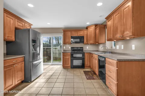 a kitchen with stainless steel appliances granite countertop a refrigerator a stove top oven a sink and dishwasher