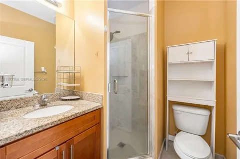 a bathroom with a granite countertop sink toilet and shower