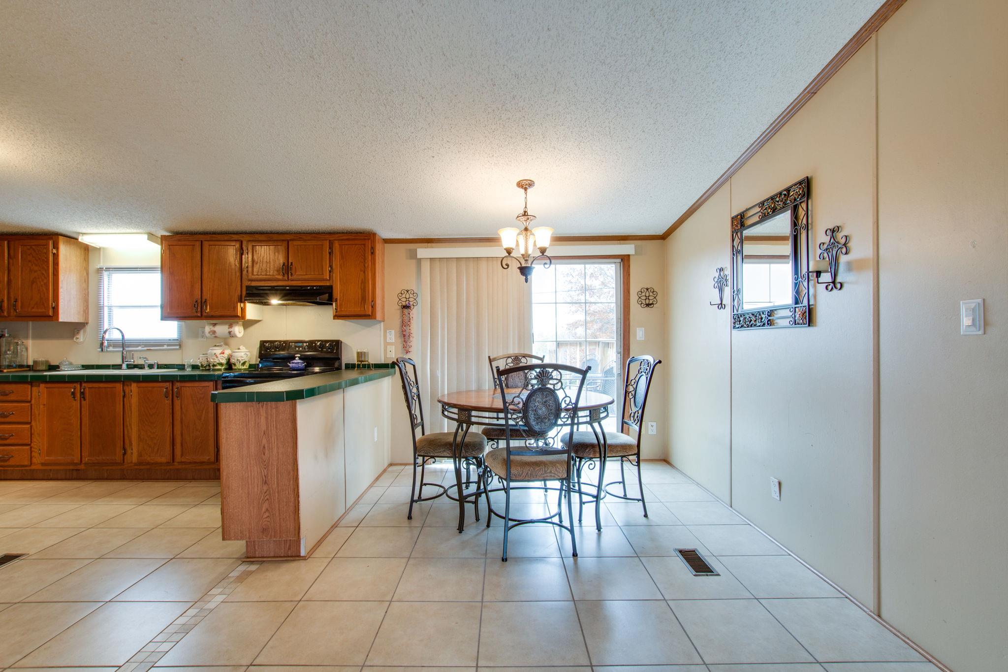 3240 Beasleys Bend Road Lebanon, TN 37087 - Photo 6 of 25 a kitchen with stainless steel appliances kitchen island granite countertop a table chairs and a refrigerator