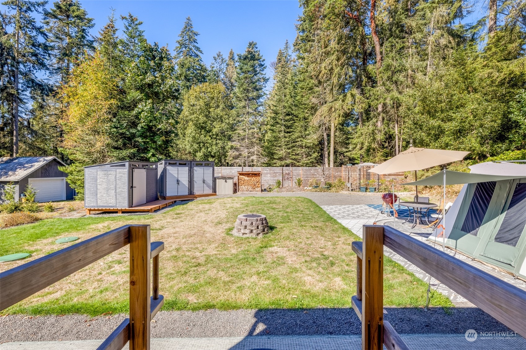 20 Willes Way Port Angeles, WA 98362 - Photo 3 of 34 a view of a backyard with table and chairs under an umbrella with large trees